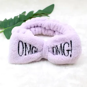 Lila Plueschhaarband mit suesser Schleife und gesticktem OMG Text, weicher Flanell fuer Spa.