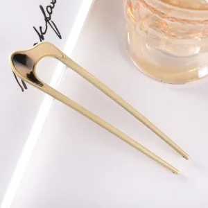 Minimalist metal U-shaped hair fork with acetate detail for elegant buns and updos.