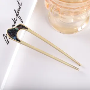 Modern minimalist U-shaped hair fork, matte gold metal hair accessory for women styling.