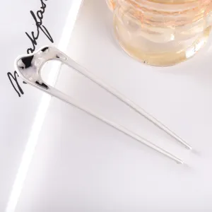 Minimalist metal U-shaped hair fork detail, elegant hair styling accessory for women.