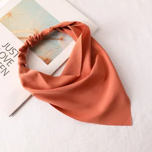 Foulard triangulaire en mousseline orange unie et bande elastique pour coiffure de femme chic.