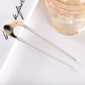 Closeup detail view of a modern minimalist U-shaped acetate hair stick, elegant hair accessory.
