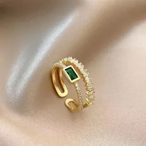 Vue détaillée d'une bague ouverte en zircon vert rétro avec des cristaux étincelants et finition dorée.