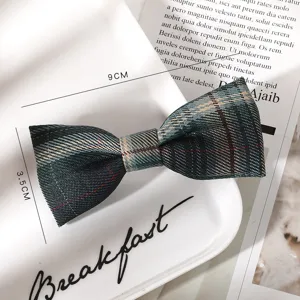 Close up of a green plaid bow hair clip, school style JK hair accessory detail view.