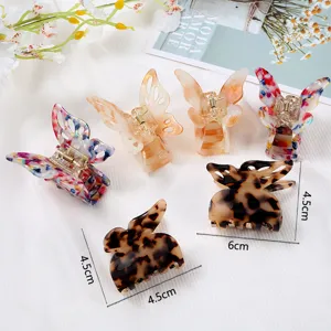 Acetate butterfly hair claw clips with elegant marble and tortoise shell patterns, detail view.