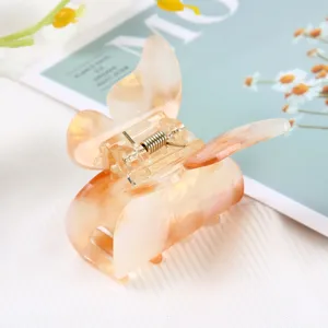 Close-up detail of translucent amber marble butterfly hair claw clip with metallic spring.