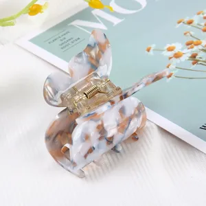 Detailed closeup of the stylish marble pattern butterfly hair claw clip with metal spring.