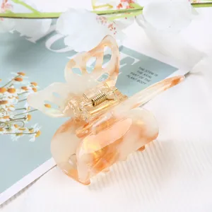 Detailed close-up of translucent butterfly hair claw clip with marble acetate design and spring.