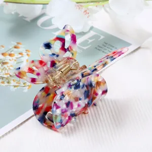 Close-up detail of the colorful butterfly acetate hair claw clip, showing exquisite texture.