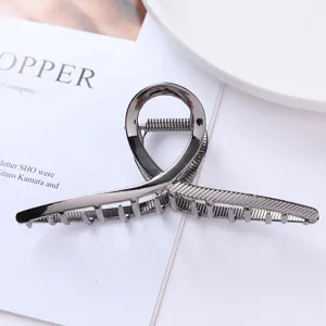 Close-up detail of geometric metal hair claw clip in gunmetal color, elegant and sturdy design.