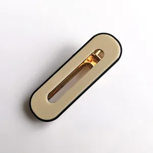 Close-up detail of minimal oval acrylic hair clip with gold metal spring mechanism and black rim.