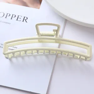 Minimalist metal hair claw clip in soft pastel yellow, elegant matte finish for secure daily styling.