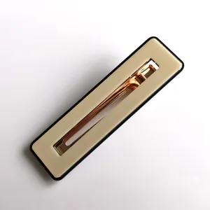 Detail shot of a rectangular acrylic hair clip in beige with black trim and gold clasp.