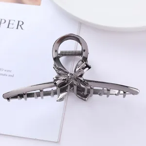 Metal hair claw detail shot, elegant bow design, sturdy grip for daily styling and elegant updos.