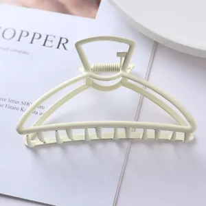 Minimalist metal hair claw clip detail shot, elegant cream yellow finish for daily ponytails.