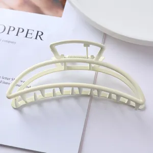 Close up view of the elegant cream metal hair claw clip, highlighting smooth hollow shape.