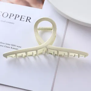 Metal hair claw clip detail shot, elegant cream geometric design for daily hairstyles.