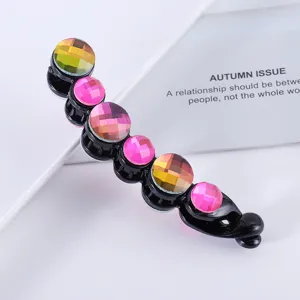 Rhinestone banana hair clip detail view, sparkling colorful crystal stones on black plastic base.