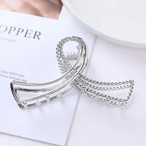 Close-up detail view of a stylish silver metallic hair claw clip with hollow geometric design.