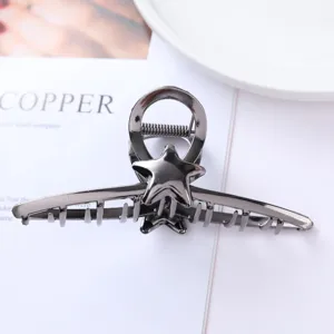 Detail of geometric metal hair claw with star design, dark grey hair accessory for women.