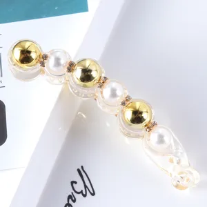 Closeup detail view of a trendy Korean style minimalist gold pearl rhinestone banana hair clip.