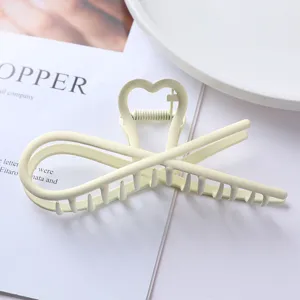 Metal hair claw clip detail close-up showing the unique heart design and smooth matte finish.