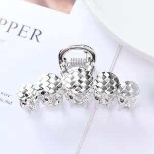 Detailed close-up of the silver metal hair claw featuring an intricate woven texture design.