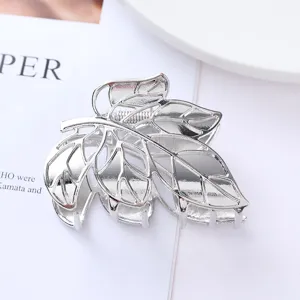Silver metal leaf hair claw clip detail, elegant hollow design for secure hairstyling accessory.