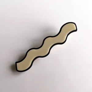 Detailed view of a wavy acrylic hair clip with black border, chic side hairpin accessory.