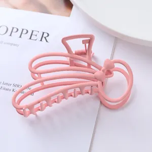 Detail view of the pink metal hair claw clip featuring a cute bow cutout design and matte finish.