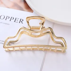 Gold metal hair claw clip detail view, elegant minimalist hair accessory for daily styling.