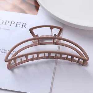 Close up of a minimalist matte pink geometric metal hair claw clip, perfect for stylish updos.