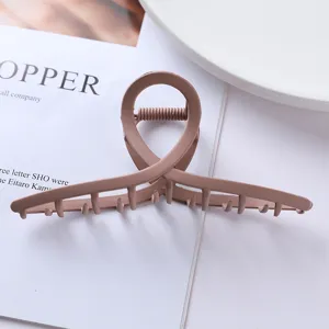 Close-up detail of matte pink geometric hair claw clip, showing cross circular design texture.
