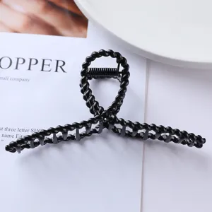 Black metal hair claw clip with twisted geometric design detail shot for stylish daily hairstyles.