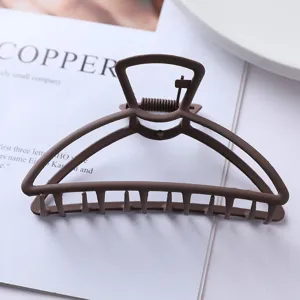 Matte brown metal hair claw clip detail shot, showing sturdy teeth and unique top arch design.