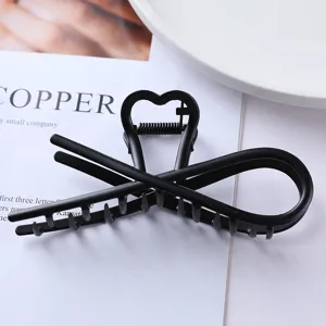 Matte black metal hair claw clip with geometric heart design for women daily hair styling.