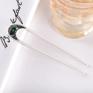 Minimalist U-shaped metal hair fork with abalone shell inlay, perfect for elegant buns and updos.