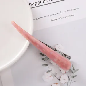 Close-up detail of the pink acetate hair clip showing smooth marbled texture and metal clip.