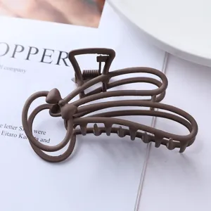 Brown matte metal hair claw clip, stylish minimalist bunny shape close up detail view.