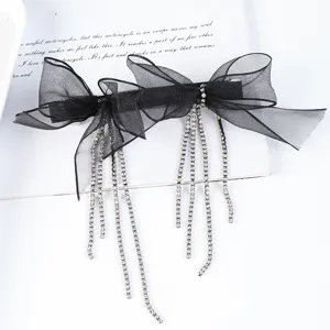 Close-up of black organza bow hair clip with rhinestone tassel chains for elegant styling.