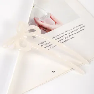 Close-up detail of white acetate butterfly hair stick, elegant hollow bun hairpin accessory.