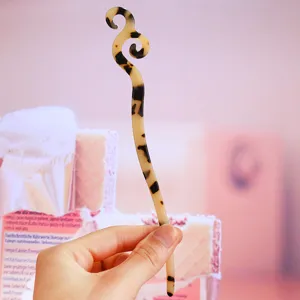 Acetate hair stick detail showcasing the elegant tortoiseshell pattern and unique curved shape.