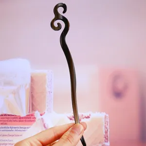 Close-up view of the elegant dark swirl acetate hair fork, showcasing smooth polished texture.