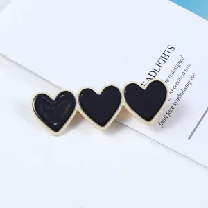 Detail view of Korean style black and white triple heart acrylic hair clip, simple fashion.