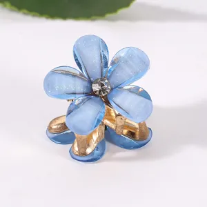 Nahaufnahme der blauen Glitzer Blumen Haarklammer im Detail mit funkelndem Strassstein.