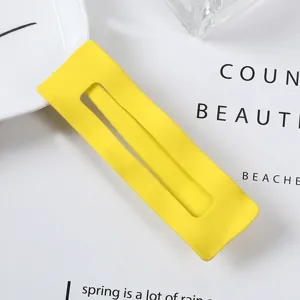 Detail shot of a bright yellow rectangular hair clip, metal side clip for chic daily styling.