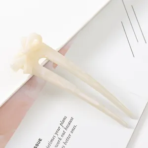 Minimalist milky white acetate U-shaped hair fork with cute bow detail for elegant buns.