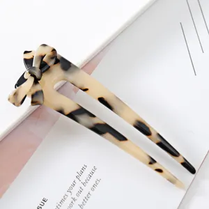 Close-up detail of the elegant tortoiseshell acetate bow hair stick, chic and stylish design.