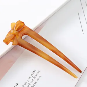 Detailed close-up of the elegant amber acetate bow hair fork, perfect for stylish buns and updos.