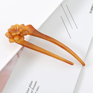 Detailed view of the amber acetate U-shaped hair fork with delicate flower design for buns.